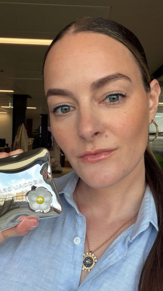 woman holding bronzer in selfie